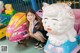 A young girl sitting on top of a toy car.