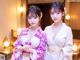 Two young women in kimonos standing next to each other.