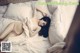 A woman laying on top of a bed covered in white sheets.