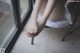 A woman sitting on a chair with her feet up on a window sill.