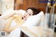 A woman laying in bed with her hand on her chin.