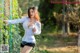 A woman in a white shirt and black shorts posing for a picture.