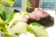 A woman laying on a window sill next to a plant.