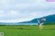 A woman in a field with a hat on her head.