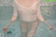 A woman in a white shirt is standing in a pool.